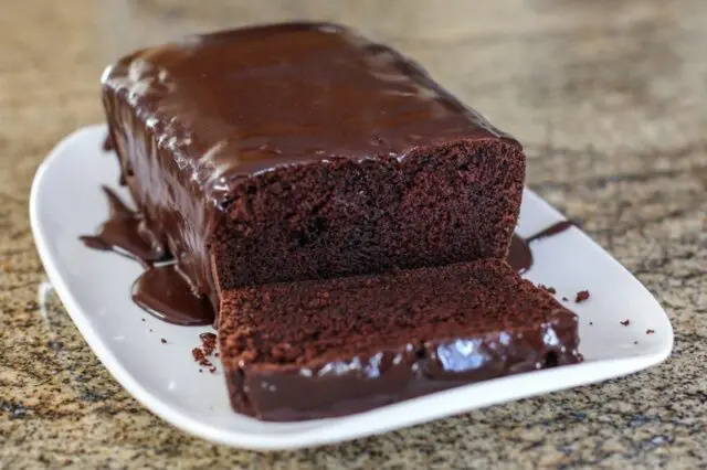 A chocolate loaf cake on a serving tray.