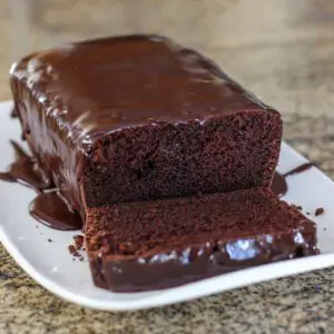 Moist chocolate loaf cake on a platter, sliced.