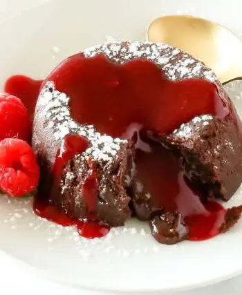 chocolate molten lava cake on a plate with raspberries and mint