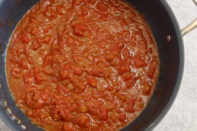 Simmer the tomato sauce with the onions and spices.