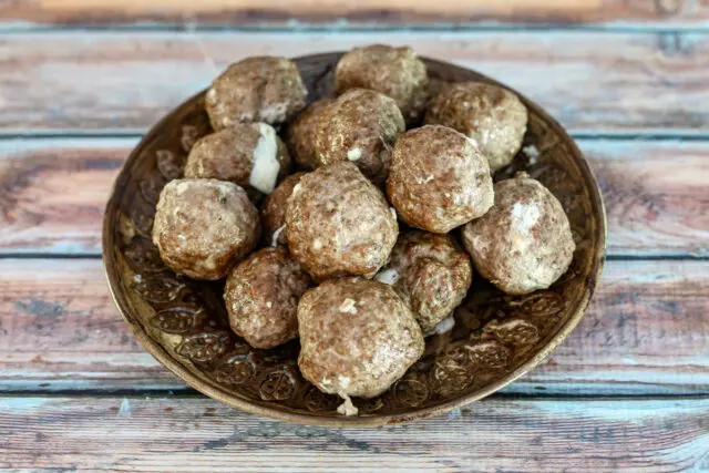 Mozzarella stuffed meatballs on a plate.