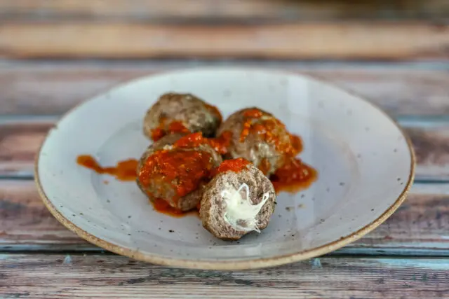 A plate with mozzarella stuffed meatballs.