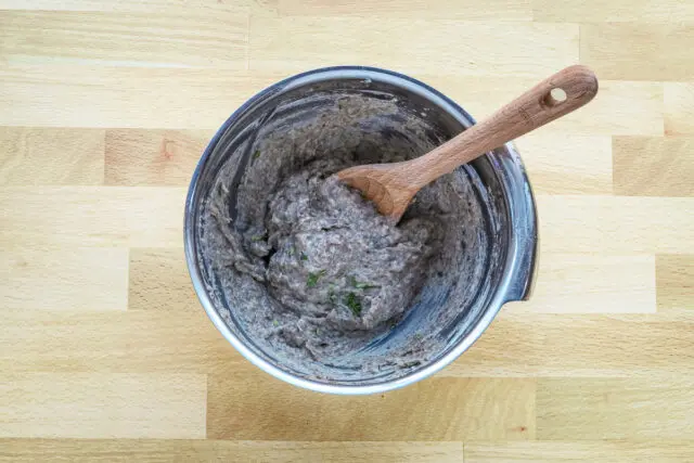 Mushroom duxelles mixing with sour cream and seasonings for mushroom tarts.