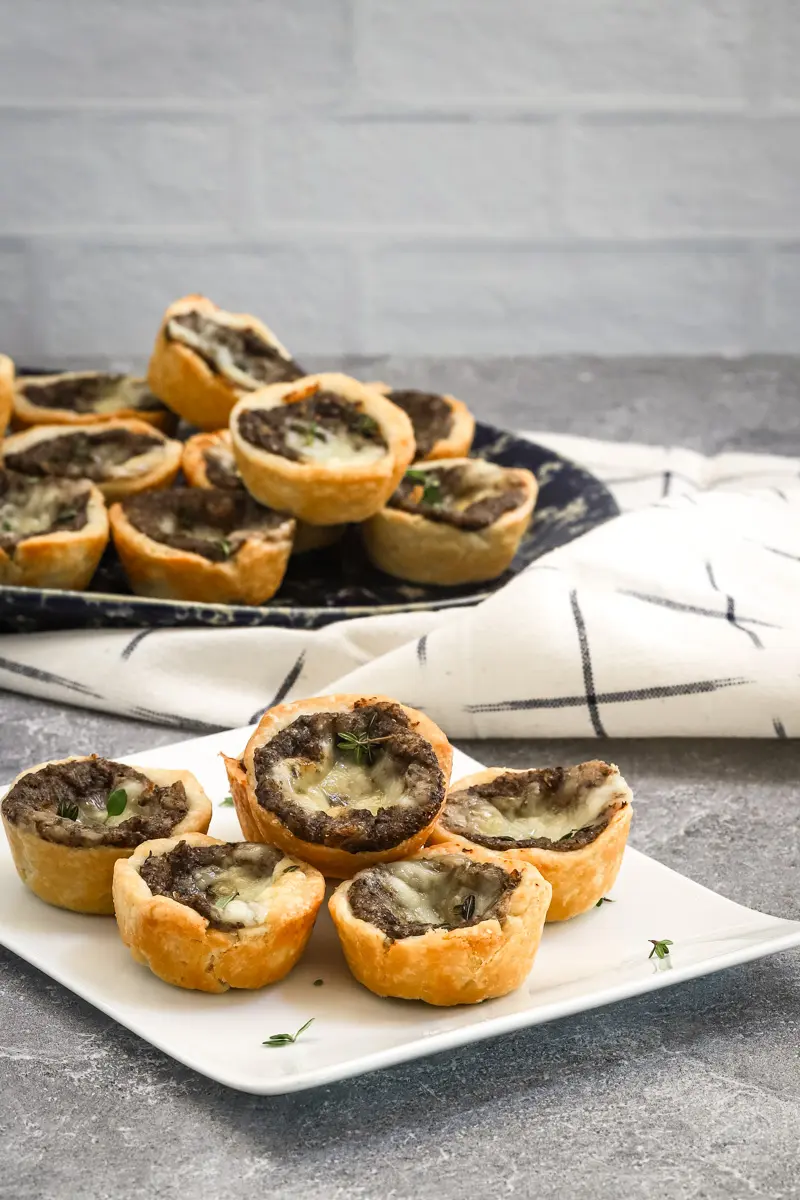 Mushroom tartlets being served with a scattering of thyme.