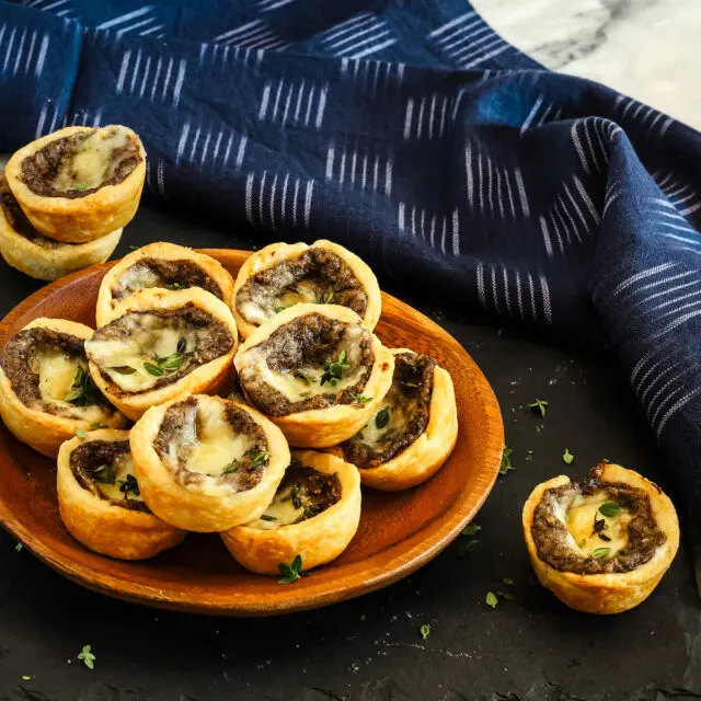 Mushroom and fontina cheese tartlets in a serving dish.