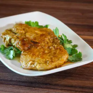 a small platter with mustard and apple jelly glazed pork chops