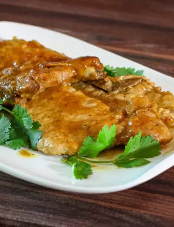 mustard glazed pork chops on a plate with cilantro