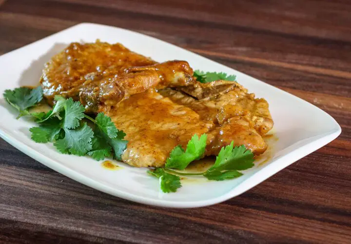 mustard glazed pork chops on a plate with cilantro