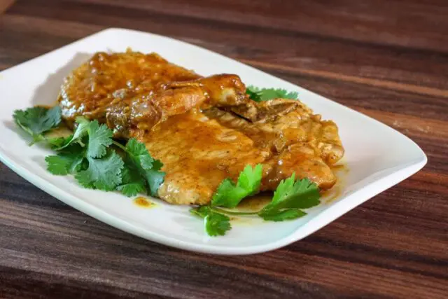 mustard glazed pork chops on a plate with cilantro