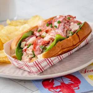 A generously filled lobster roll in a toasted New England hot dog roll.