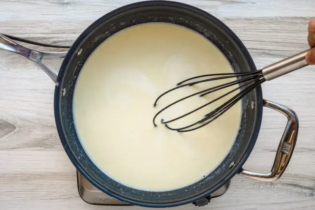 Milk is added to the roux for the macaroni and cheese sauce.