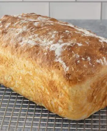 A loaf of no-knead bread on a cooling rack.
