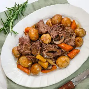 an onion soup pot roast from the slow cooker, shown on a serving platter with vegetables