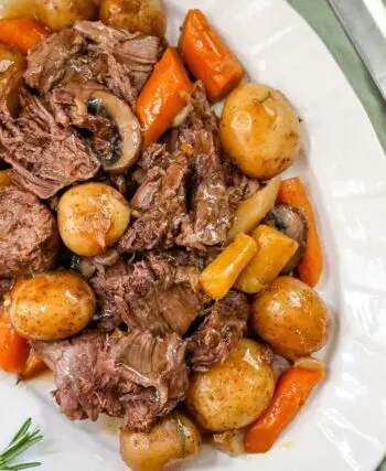 a pot roast with potatoes, carrots, and onion soup