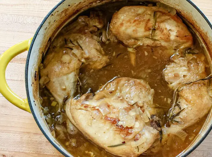 Oven braised chicken with rosemary, shown in the Dutch oven.