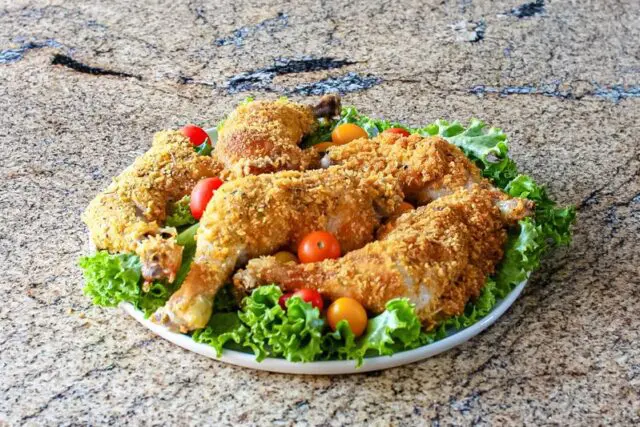 Cornflake crusted chicken on a platter with tomatoes and lettuce.