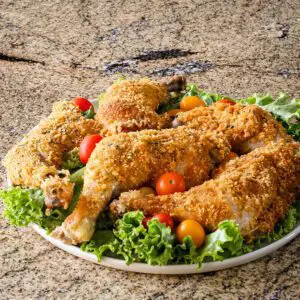 Oven fried cornflake coated chicken pieces on a platter.