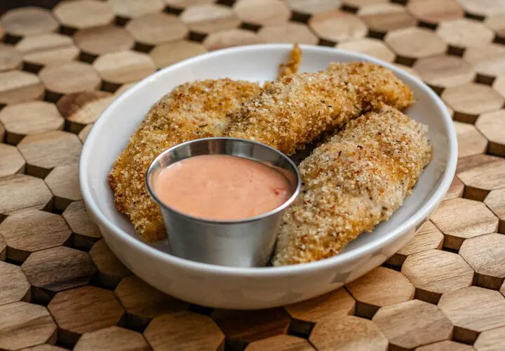 bacon and panko coated chicken tenders on a plate with dip