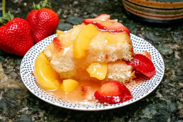 peaches and strawberry dessert sauce over angel food cake