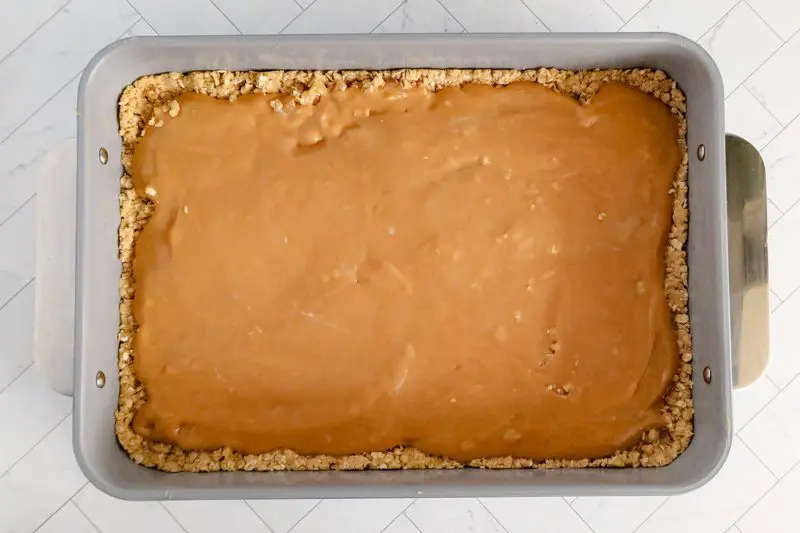 spread the peanut butter batter over the oat crust layer.