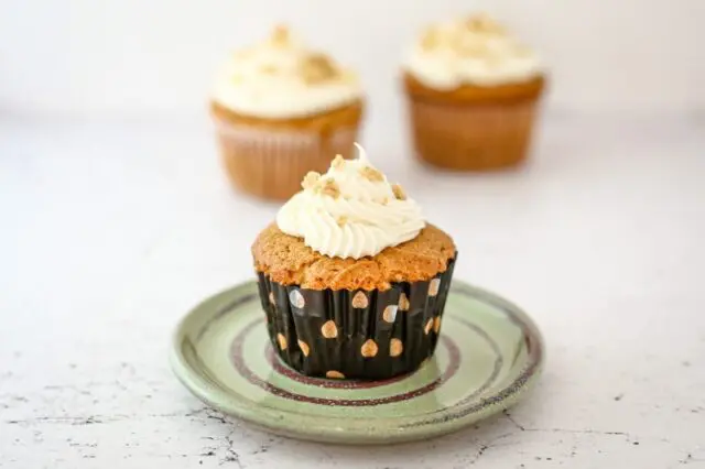 a peanut butter cupcake on a small plate, frosted