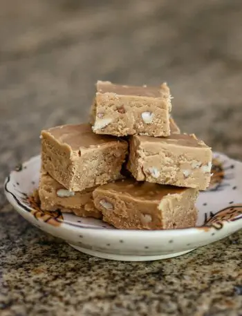 peanut butter fudge is stacked on a small plate