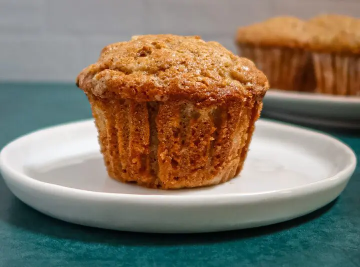 A pear muffin on a plate with more in the background