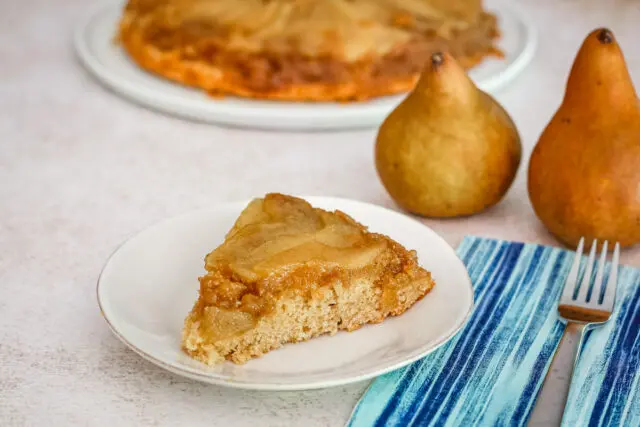 A slice of pear upside-down cake on a plate.