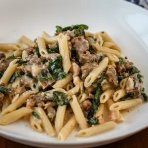 penne with sausage and spinach served in a bowl