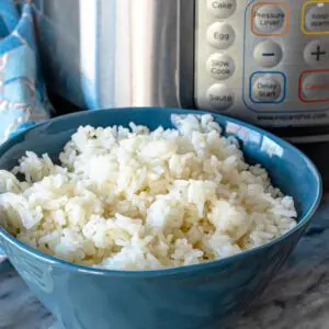 instant pot rice in a blue bowl next to the instant pot