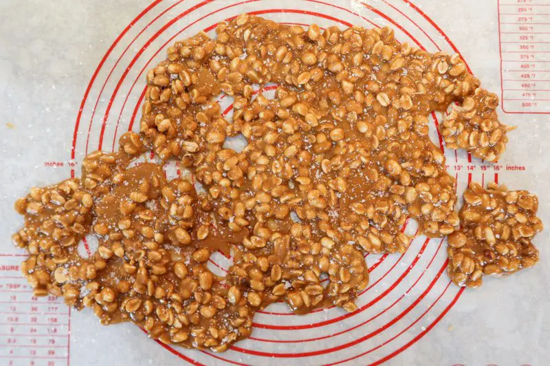 Peanut brittle poured out onto a silicone pastry sheet