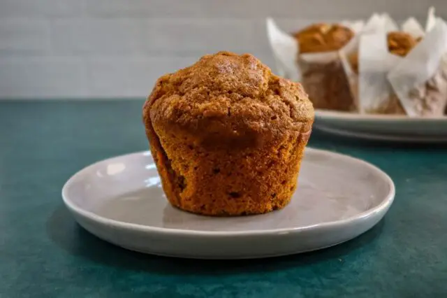 A pumpkin muffin on a small plate