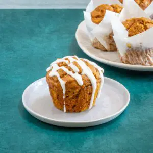 An iced pumpkin muffin on a plate