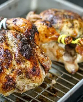 pesto coated Cornish game hens in a roasting pan