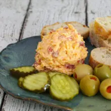 pimento cheese with pickles, olives, and baguette slices