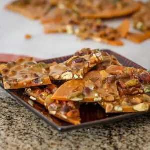 pistachio brittle with flaky sea salt on a serving plate.