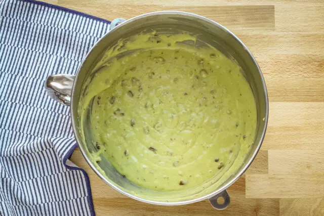 Pistachio cake batter in a mixing bowl.