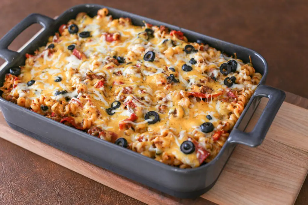 baked pizza casserole in the baking dish on a cutting board