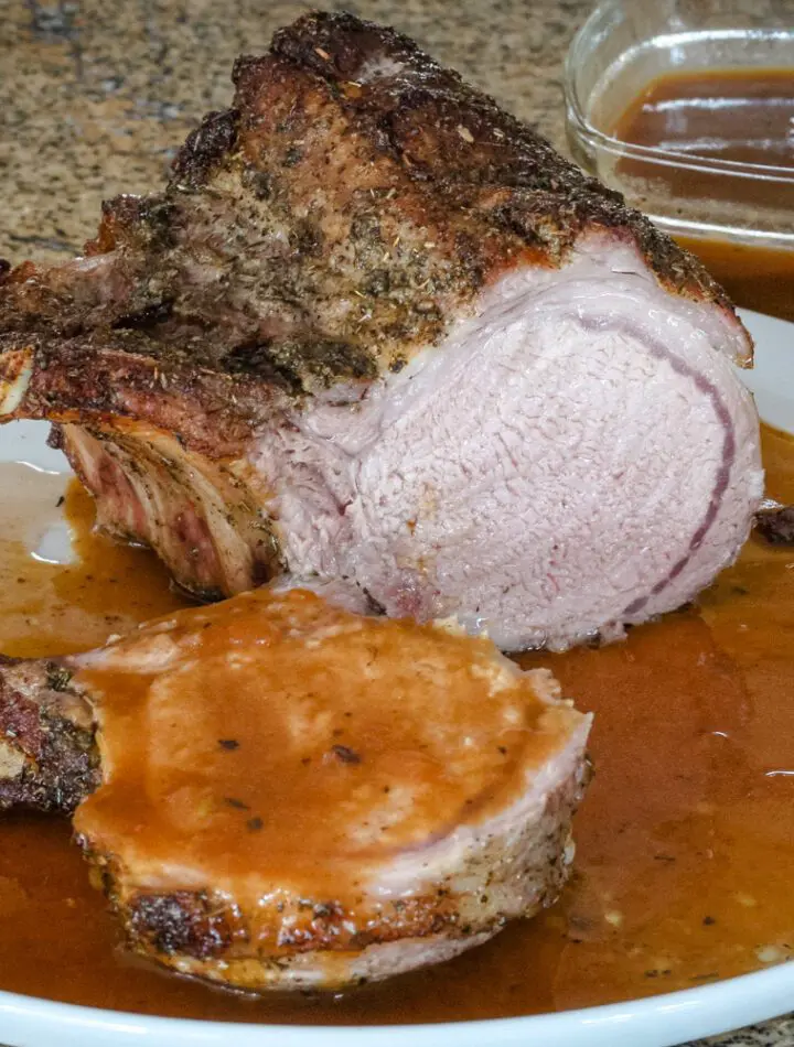 pork rack with madeira pan sauce on a serving plate.