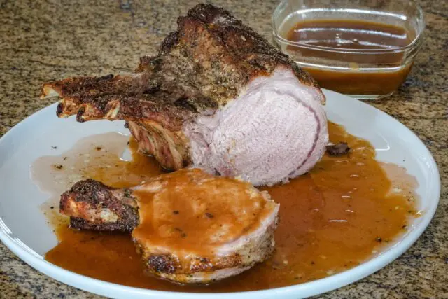 pork rack with madeira pan sauce on a serving plate.