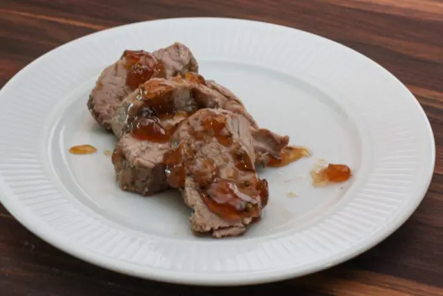 roasted pork tenderloin with jalapeño pepper glaze on a plate, sliced