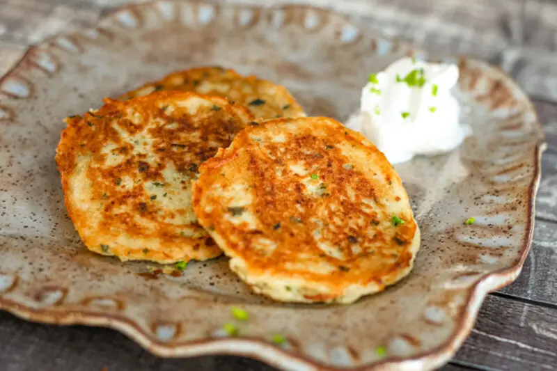 potato pancakes on a plate with sour cream and chives