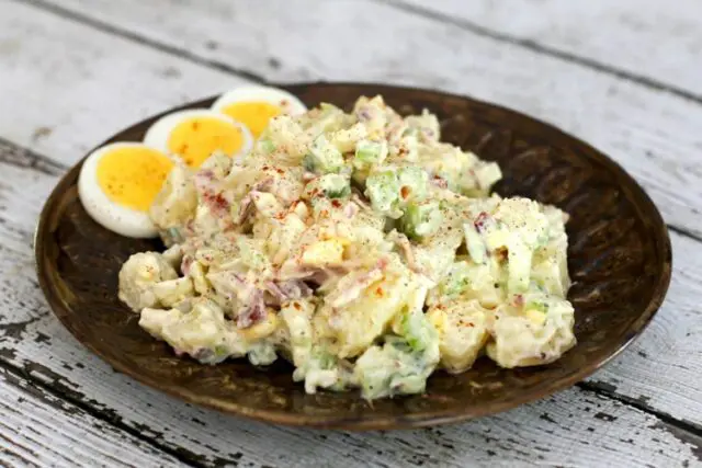 buttermilk potato salad on a plate with extra sliced hard boiled eggs.