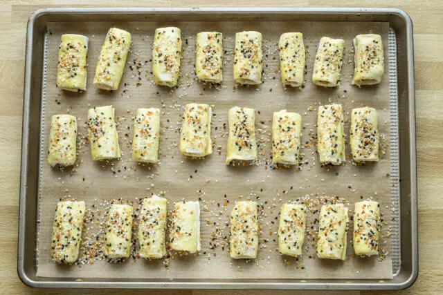 Baking sheet with puff pastry pigs in a blanket ready to bake.