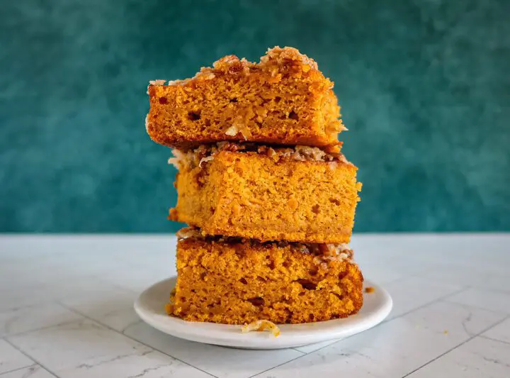 pumpkin cake with broiled coconut pecan topping, stacked on a plate