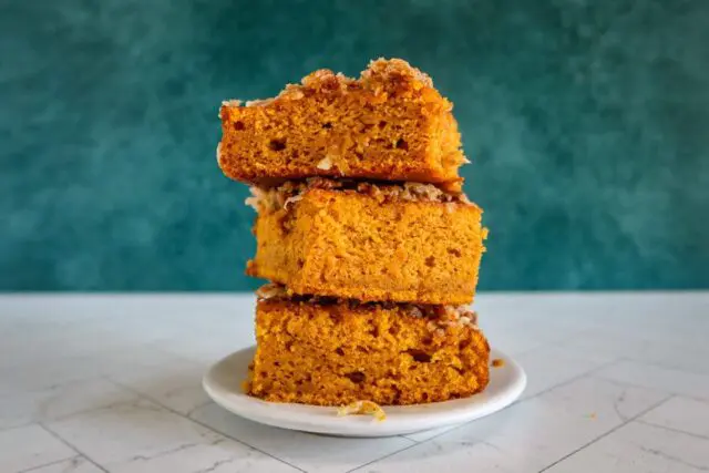 pumpkin cake with broiled coconut pecan topping, stacked on a plate