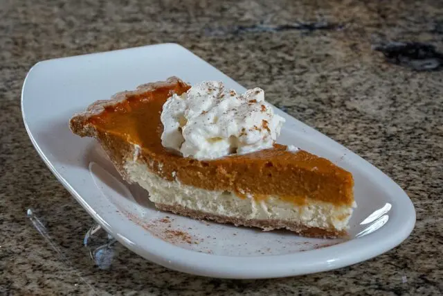 pumpkin pie with cream cheese layer on a dessert plate