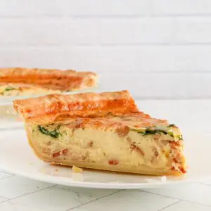 A slice of quiche lorraine with spinach