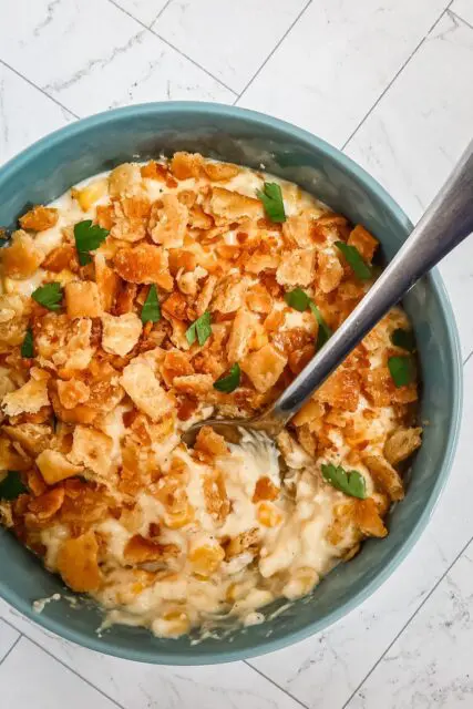 quick skillet scalloped corn in a serving bowl with spoon