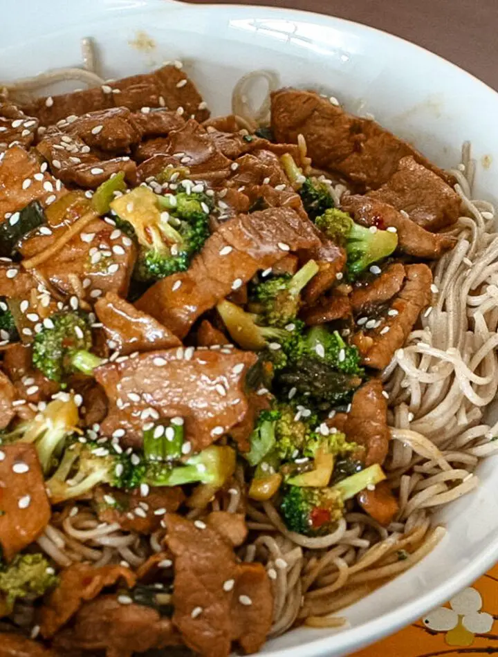 sesame noodles in a bowl with a meat stir-fry